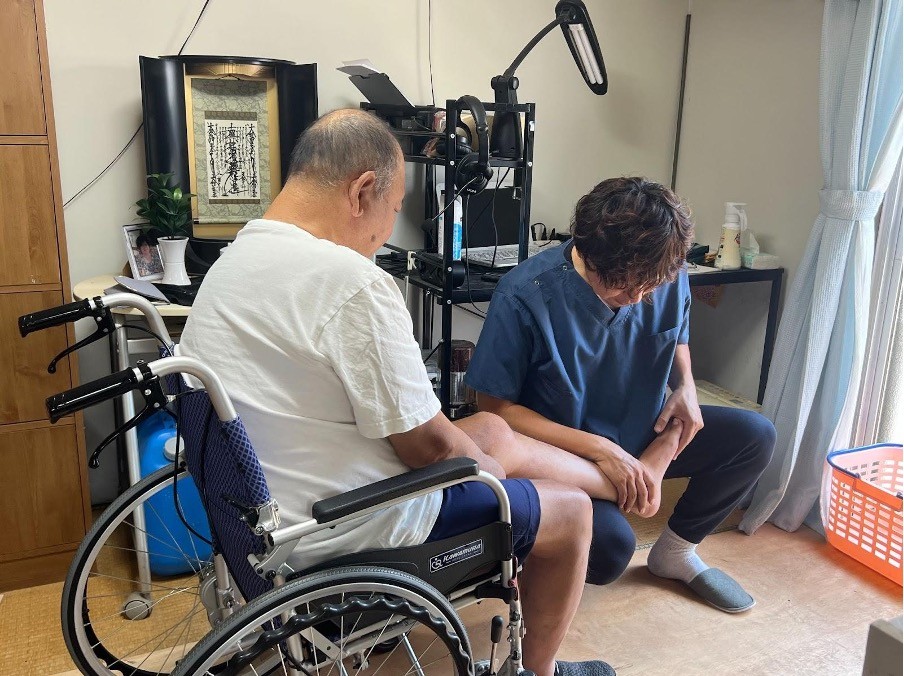 車椅子の男性がリハビリセラピストにリハビリテーションを受けている様子