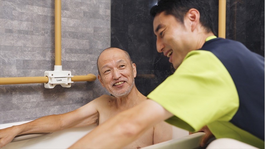 介護士に入浴介助をうける高齢者