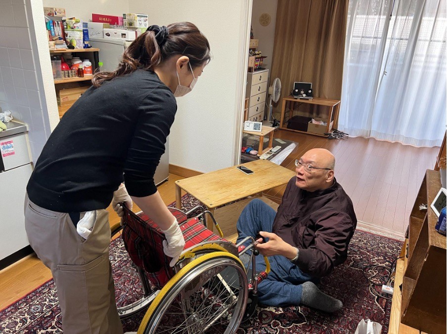 脳性麻痺の大小島さんと車椅子の移乗介助する女性ヘルパー