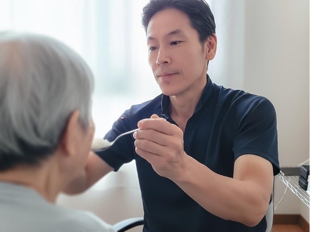 男性ヘルパーが食事介助する様子