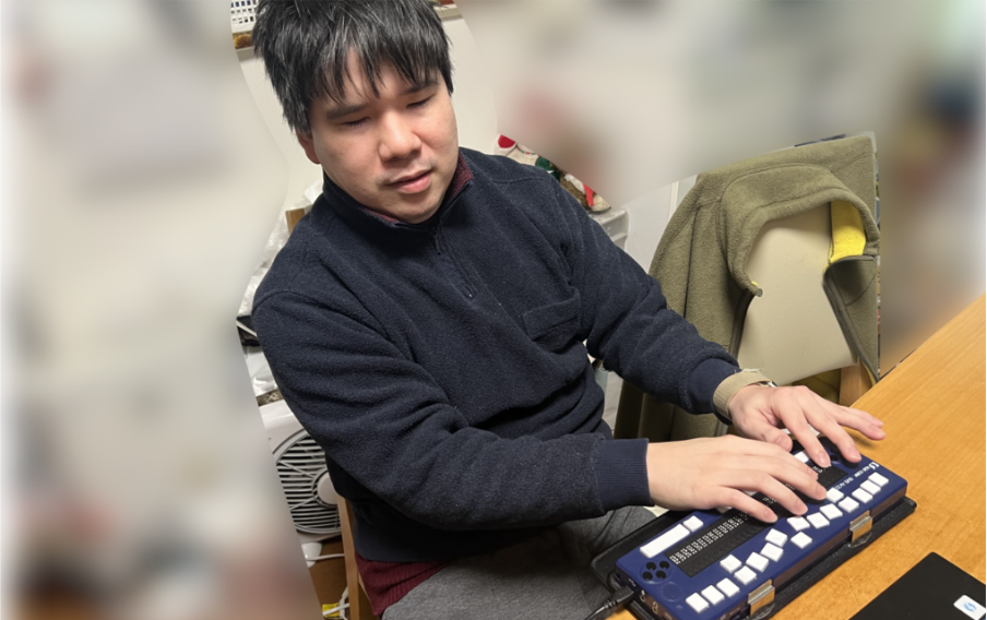 視覚障がいのある方が点字ディスプレイを操作している様子